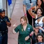 La actriz estadounidense Amy Schumer (c) y la modelo estadounidense Emily Ratajkowski (d-detr&aacute;s) gesticulan despu&eacute;s de ser detenidas.