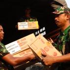 Miembros de las fuerzas de seguridad indonesias distribuyen material de supervivencia y medicamentos.