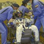 Un grupo de especialistas ayuda a Chris Hadfield, miembro canadiense de la tripulación de la Estación Espacial Internacional, a levantarse después de comprobar su traje espacial en el Cosmódromo de Baikonur en Kazajistán. Diciembre de 2012.