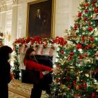 Unas visitantes comentan las fotos colgadas en los &aacute;rboles del sal&oacute;n de cenas oficiales, en la Casa Blanca.
