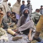 Afganos sentados junto a la mansión de Gul Agha, autonombrado gobernador tras la caída de los talibanes en Kandahar.