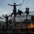 Unos jóvenes africanos gritan &ldquo;libertad&rdquo; y piden clemencia a los policías españoles que les interceptaron en lo alto de la valla, en su intento de entrar en Melilla. En 2015, cerca de 11.624 personas migrantes entraron por Meli...