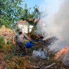 Un hombre extingue el fuego este lunes en Atalaia Fundeira con una regadera.