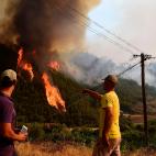 Dos personas gesticulan hacia las llamas cerca de Pampilhosa da Serra.