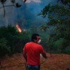 Un vecino de Figueiro dos Vinhos se planta frente al fuego con una manguera y una mascarilla.