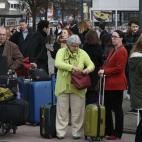 Los pasajeros evacuados se arremolinan en las inmediaciones del aeropuerto con sus pertenencias.