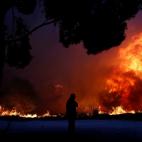 Un hombre mira las llamas que arden en Rafina, cerca de Atenas.