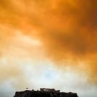 El Parten&oacute;n y la Acr&oacute;polis bajo un cielo naranja por las llamas y el humo de los incendios.