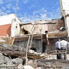Varios agentes y empleados de Prosegur inspeccionan las ruinas del edificio de la empresa que ha explotado en el asalto.