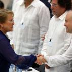 La presidenta de Chile, Michelle Bachelet (i) saluda a Camilo Lozada de la guerrilla colombiana de las FARC
