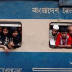 Pasajeros se asoman a las ventanas en un tren abarrotado de pasajeros que van celebrar el festival Eid al-Fitr, que marca el fin del Ramadan, en Bangladés.