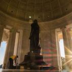 Los primeros rayos de sol se cuelan entre las columnas del memorial del Thomas Jefferson mientras un empleado limpia la estatua del ex presidente de los Estados Unidos.