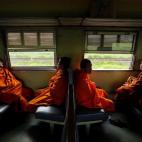 Un grupo de monjes turistas viajan en tren dirección al templo de Ayutthaya a las afueras de Bangkok, Tailandia.