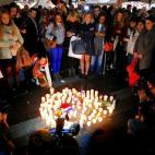 Miembros de la comunidad francoaustraliana se congregan alrededor de unas velas durante una vigilia en Sidney.