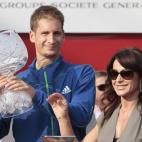 El alemán Florian Mayer, izquierda, sostiene el trofeo del Abierto de Bucarest de Tenis, que le entregó Nadia Comaneci, derecha.