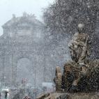 Vista de la fuente de Cibeles bajo la intensa nevada ca&iacute;da esta ma&ntilde;ana en el centro de Madrid.
