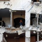 Dos mujeres miran lo que queda entre los escombros de su casa en Gaza.&nbsp;