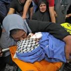 La madre del palestino Hussein al-Titi, de 26 años, asesinado por disparos israelíes en el campo de refugiados de Fawwar, cerca de la ciudad de Hebrón, en la ocupada Cisjordania, llora su cuerpo