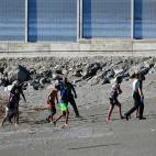 Algunos jóvenes hablan con la Guardia Civil tras llegar a nado a Ceuta.