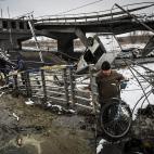 Un hombre cruza un r&iacute;o en Kiev tras el derrumbe del puente