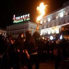 Una de las imágenes de los disturbios en Madrid: un manifestante levanta un objeto en llamas