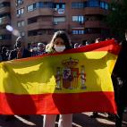 A supporter of far-right party Vox holds a Spanish flag during the presentation of Vox candidate for Madrid Regional election in the Madrid's suburb of Vallecas on April 7, 2021. (Photo by JAVIER SORIANO / AFP) (Photo by JAVIER SORIANO/AFP via G...