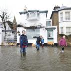 Un grupo de niños juega en una calle inundada en Datchet, cerca de Londres. La respuesta del Gobierno a las inundaciones está recibiendo críticas de muchos ciudadanos que viven en las zonas más destrozadas por el temporal y que consideran q...
