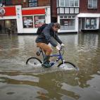 Un joven ciclista intenta avanzar a través del agua en Datchet, Reino Unido. David Cameron ha prometido esta mañana desde una de las áreas afectadas por el desbordamiento que pondrá todo el dinero y medios necesarios para afrontar "este eno...