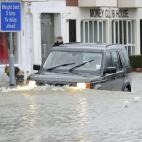 Un vehículo todoterreno avanza a través de una calle inundada en Datchet, cerca de Londres. Las autoridades han movilizado a 1.600 soldados para contribuir a las labores de ayuda.