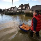 Un niño lleva bolsas de arena en una carretilla en medio del agua en Wraysbury, Berkshire. Las calles de la localidad han quedado inundadas por el desbordamiento del río Támesis.