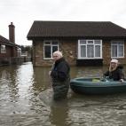 Vecinos que dejan su casa, afectada por las inundaciones, cerca de Londres. Los residentes de Wraysbury han tenido que abandonar sus casas y utilizan lanchas para recorrer las calles inundadas de la ciudad.