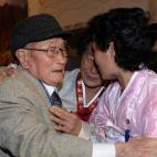 Ryu Young-Shik de 92 años saluda a dos de su parientes de Corea del Norte.