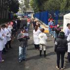 Juarez public hospital health workers wait on a street after a 7.5 earthquake sent them out from their work areas, in Mexico City, Tuesday, June 23, 2020. The earthquake centered near the resort of Huatulco in southern Mexico swayed buildings Tu...