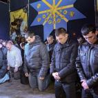 Policías ucranianos se arrodillan ante los residentes de Lviv para pedir perdón por la represión gubernamental contra las protestas en Kiev.