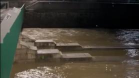 El irreconocible río Manzanares circula caudaloso por Madrid con amenaza de desbordamiento
