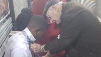 Un anciano enseña a un joven a hacerse el nudo de corbata en el metro