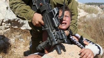 Mujeres y niños palestinos tratan de impedir el arresto de un niño por parte de un soldado de Israel (FOTOS)