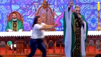 Una mujer empuja a un sacerdote en plena misa