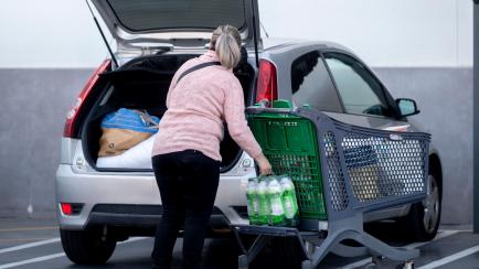 Una mujer pone la compra en el maletero del coche al salir del supermercado en Madrid. 