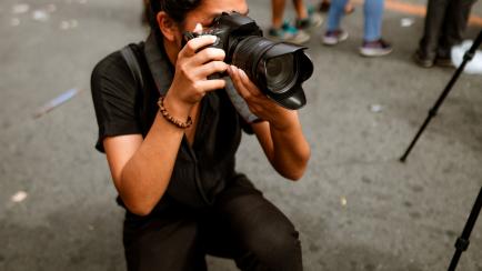 Young Filipino student photojournalist taking photographs