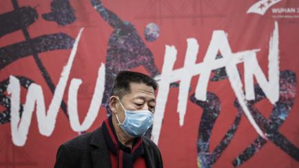 Un ciudadano chino de la ciudad de Wuhan con mascarilla para evitar contagiarse