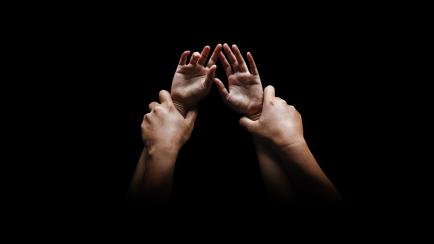 Man hands holding a woman hands for rape and sexual abuse concept isolated on black background