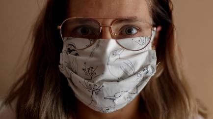 MADRID, SPAIN - MARCH 25: The photographer's wife, poses with a mask she has made with a sewing machine as part of a group of friends' initiative to donate masks for coronavirus protection on March 25, 2020 in Madrid, Spain. (Photo by Eduardo Pa...