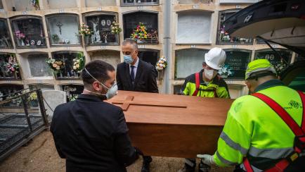 GIRONA, CATALONIA, SPAIN - 2020/04/17: Funeral workers and gravediggers carry the coffin from the funeral vehicle during a funeral.
The Covid-19 makes funerals difficult, the situation requires workers to wear masks and are forced to limit acces...