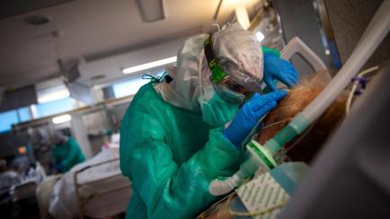 TOPSHOT - A healthcare worker attends to a COVID-19 coronavirus patient at the Intensive Unit Care of the Povisa Hospital in Vigo, northwestern Spain, on April 16, 2020. - Spain's coronavirus death toll soared past 19,000 with another 551 deaths...