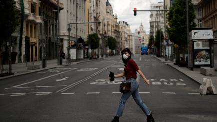 MADRID, SPAIN - APRIL 25: A woman wearing face mask as a precaution against coronavirus (Covid-19) walks past the Gran Via street in Madrid, Spain on April 25, 2020. (Photo by Burak Akbulut/Anadolu Agency via Getty Images)
