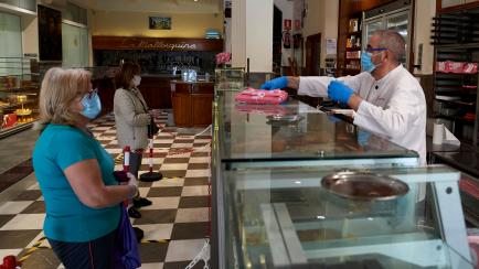 MADRID, SPAIN - MAY 05: Luis Rico dispatches a client at the La Mallorquina bakery during the second day of reopening to the public after 51 days of closure due to the coronavirus on May 05, 2020 in Madrid, Spain. Spain is re-opening businesses ...