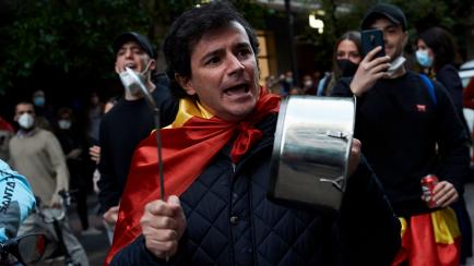 MADRID, SPAIN - MAY 13: Groups of people participate with Spanish flags, hitting saucepans and shouts calling for the resignation of the government and against the government's management of the coronavirus crisis during a protest by residents o...