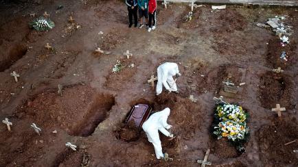 RIO DE JANEIRO, BRAZIL - MAY 08: Relatives of Neide Rodrigues, 71, who died of the coronavirus disease (COVID-19), mourn at the Caju cemetery on May 8, 2020 in Rio de Janeiro, Brazil. According to the Brazilian Health Ministry, Brazil has 135.10...