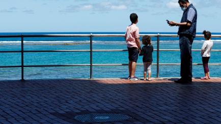 Family members are seen at promenade of Las Canteras beach after restrictions were partially lifted for children for the first time in six weeks, following the coronavirus disease (COVID-19) outbreak on the island of Gran Canaria, Spain, April 2...